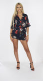 The 'LILLY ROSE' chiffon navy blue playsuit with red rose floral print and frill edge detail.