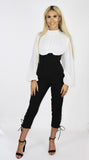The 'KOURT' black high waisted, 3/4 length lace up leg jumpsuit, with its contrast white pleated upper body  blouse, high neckand balloon sleeves.